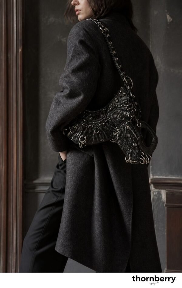 Model wearing a black heavy metal hardware moto shoulder bag